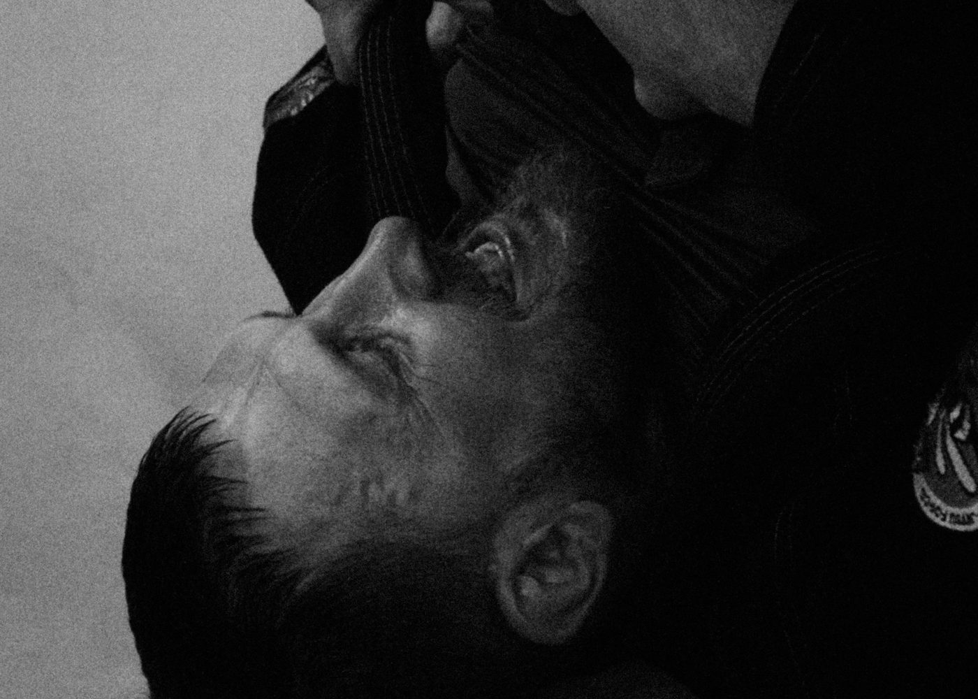 An athlete caught in a collar choke, face to the mat